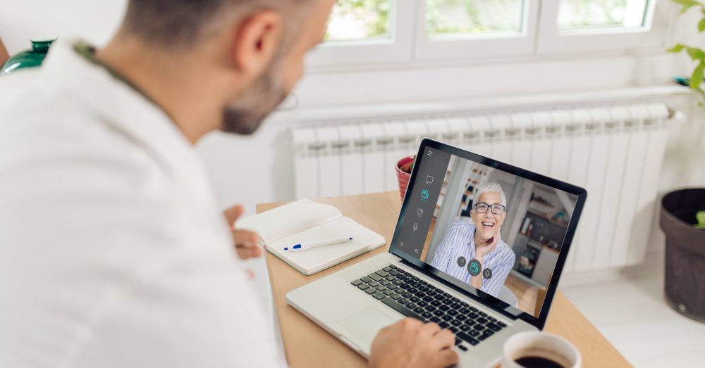 Doctor from a medical clinic  is having a video meeting with his senior patient.